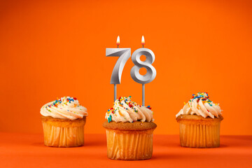 Candle number 78 - Celebration with birthday cupcake on orange background
