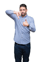 Young handsome man over isolated background Doing thumbs up and down, disagreement and agreement expression. Crazy conflict