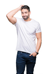 Fototapeta premium Young man wearing casual white t-shirt over isolated background confuse and wonder about question. Uncertain with doubt, thinking with hand on head. Pensive concept.