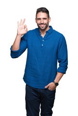 Young handsome man over isolated background smiling positive doing ok sign with hand and fingers. Successful expression.