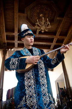 Kazakh man in national ethnic costume with chapan and dombra