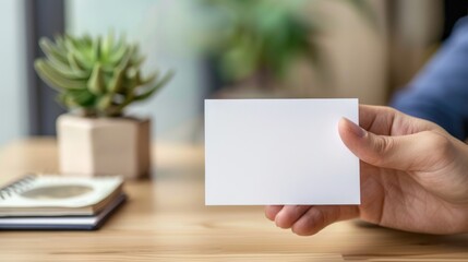 Obraz premium A person is holding a blank white card in their hand