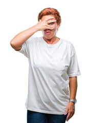 Atrractive senior caucasian redhead woman over isolated background peeking in shock covering face and eyes with hand, looking through fingers with embarrassed expression.