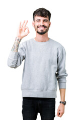 Young handsome man wearing sweatshirt over isolated background smiling positive doing ok sign with hand and fingers. Successful expression.