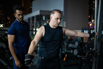 Man Working Out With Trainer at a Late Night Gym