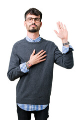 Young handsome smart man wearing glasses over isolated background Swearing with hand on chest and...