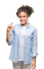 Young afro american woman over isolated background smiling and confident gesturing with hand doing size sign with fingers while looking and the camera. Measure concept.