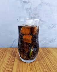 A typical Brazilian glass of cola with ice and lemon.