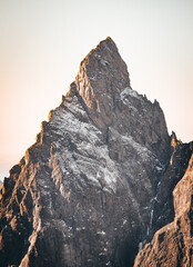 Mountain peak partially covered by snow at sunset, Alps, Italy