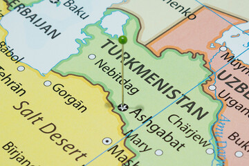 Close up to a Ashgabat city with a green pin needle into Turkmenistan country political map 