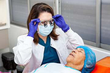 Dermatologist carrying out a skin biopsy on the face of a senior adult patient