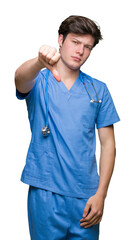 Young doctor wearing medical uniform over isolated background looking unhappy and angry showing rejection and negative with thumbs down gesture. Bad expression.