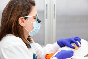 Dermatologist carrying out a skin biopsy on the face of a senior adult patient. Application of anesthesia.