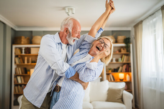 Senior active couple husband and wife dance and enjoy together at home