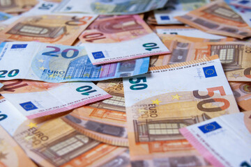 Stack of euro money cash close-up. Top view of a lot of banknotes. European currency banknotes scattered on the table.