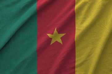 Cameroon flag depicted on folded wavy fabric of old cloth close up