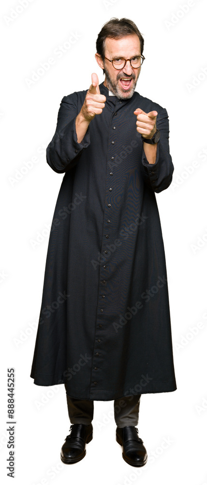 Canvas Prints middle age priest man wearing catholic robe pointing fingers to camera with happy and funny face. go