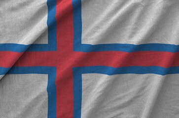 Fototapeta premium Faroe islands flag depicted on folded wavy fabric of old cloth close up