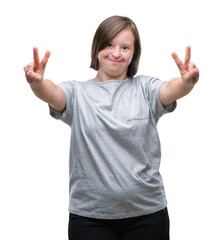 Young adult woman with down syndrome over isolated background smiling looking to the camera showing fingers doing victory sign. Number two.