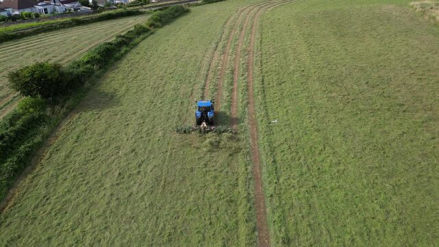 Broadsands, Torbay, South Devon, England: DRONE VIEWS: A farm tractor cuts and levels the grass in a ploughed field. South Devon is an area renowned for arable and livestock farming (Clip 6).