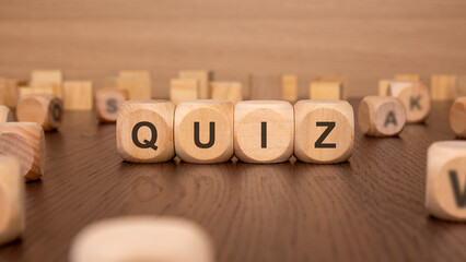 four wooden cubes with the text 'QUIZ' on a brown background
