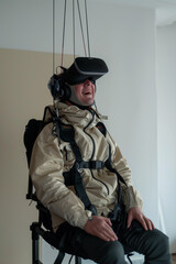Fototapeta premium A person in a wheelchair uses a virtual reality headset and headphones, engaging with a colorful screen, highlighting the inclusivity and accessibility of VR technology for individuals with disabiliti