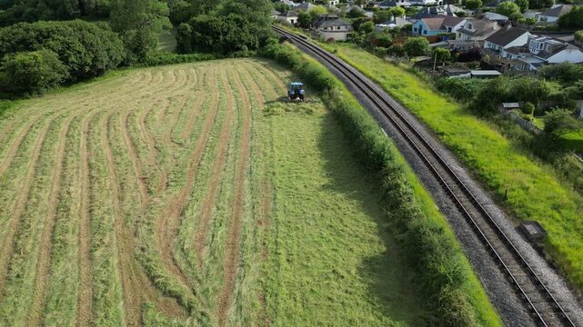Broadsands, Torbay, South Devon, England: DRONE VIEWS: A farm tractor cuts and levels the grass in a ploughed field. South Devon is an area renowned for arable and livestock farming (Clip 3).