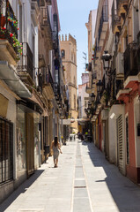 Fototapeta premium Discovering Badajoz: Young Woman Walking through the Streets of Badajoz with the Cathedral in the Background.