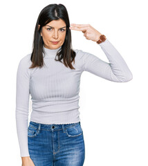 Beautiful brunette woman wearing casual clothes shooting and killing oneself pointing hand and fingers to head like gun, suicide gesture.