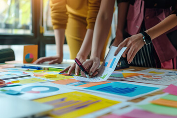 Obraz premium A group of people are sitting around a table with papers and graphs