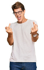Handsome caucasian man wearing casual clothes and glasses showing middle finger doing fuck you bad...