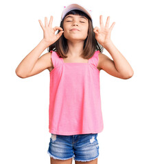 Young little girl with bang wearing funny kitty cap relax and smiling with eyes closed doing meditation gesture with fingers. yoga concept.