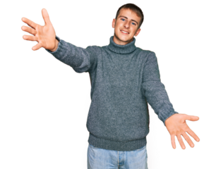 Young blond man wearing casual clothes looking at the camera smiling with open arms for hug. cheerful expression embracing happiness.