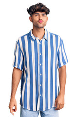 Young hispanic man wearing casual clothes looking at the camera blowing a kiss on air being lovely and sexy. love expression.