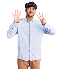 Young hispanic man wearing casual shirt showing and pointing up with fingers number eight while smiling confident and happy.