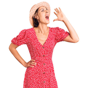 Young beautiful woman wearing summer hat shouting and screaming loud to side with hand on mouth. communication concept.