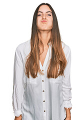 Young beautiful woman wearing casual clothes puffing cheeks with funny face. mouth inflated with air, crazy expression.