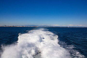 Boat leaving for vacation getaway with amazing blue scenery with snowy mountains.