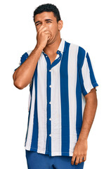 Young arab man wearing casual clothes smelling something stinky and disgusting, intolerable smell,...