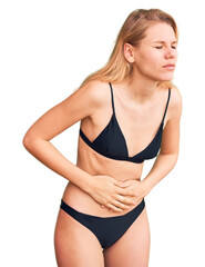 Fototapeta premium Young beautiful blonde woman wearing bikini with hand on stomach because indigestion, painful illness feeling unwell. ache concept.