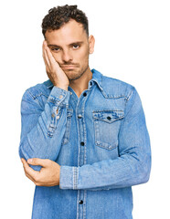 Young hispanic man wearing casual denim jacket thinking looking tired and bored with depression problems with crossed arms.