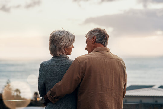 Back, morning or love and senior couple outdoor on balcony of home together with view of horizon or ocean. Holiday, sea and sky with elderly people in suburban neighborhood for bonding or vacation - Powered by Adobe