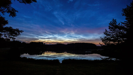 Obraz premium Sunrise over the lake and noctilucent clouds