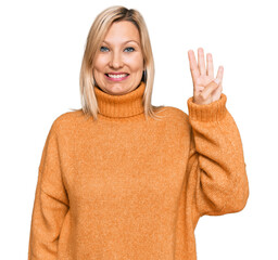 Middle age caucasian woman wearing casual winter sweater showing and pointing up with fingers number four while smiling confident and happy.