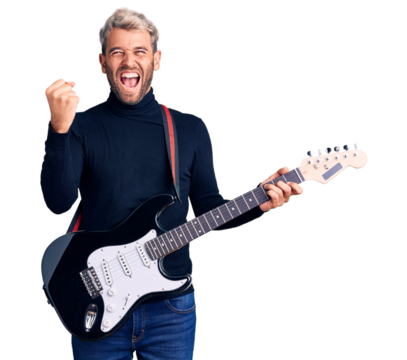 Young handsome blond man playing electric guitar screaming proud, celebrating victory and success very excited with raised arms - Powered by Adobe