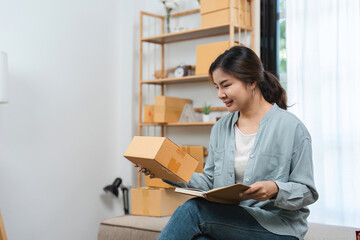 Naklejka premium Young Woman Running a Small Online Sales Business from Home, Managing Order and Packaging Products