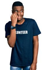 Fototapeta premium Young african american man wearing volunteer t shirt looking stressed and nervous with hands on mouth biting nails. anxiety problem.