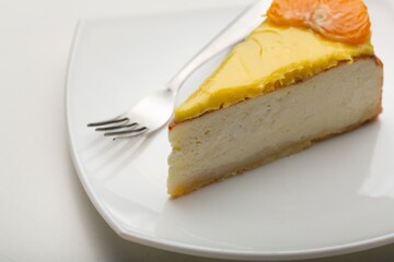 Delicious orange cheesecake with cream on plate