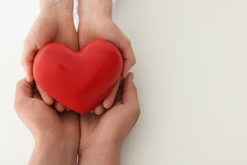 Obraz premium Doctor and patient holding red heart on white background, top view. Space for text