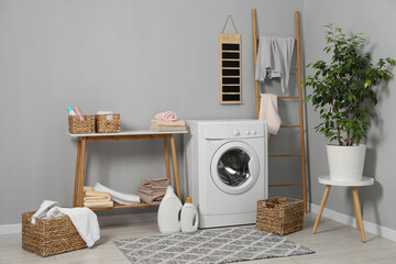 Washing machine, storage bench, detergents, laundry and houseplant indoors